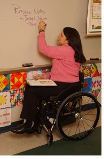 wheelchair user writing on a whiteboard