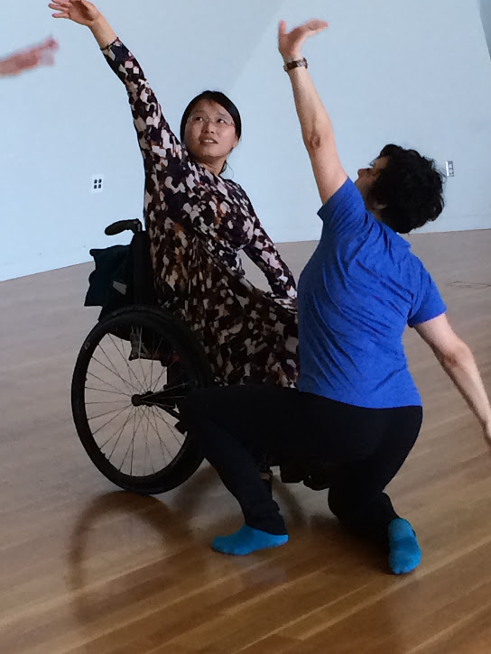 a wheelchair user dances with her non-wheelchair using partner